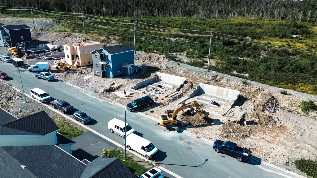 Construction site with a partially built building and an excavator.