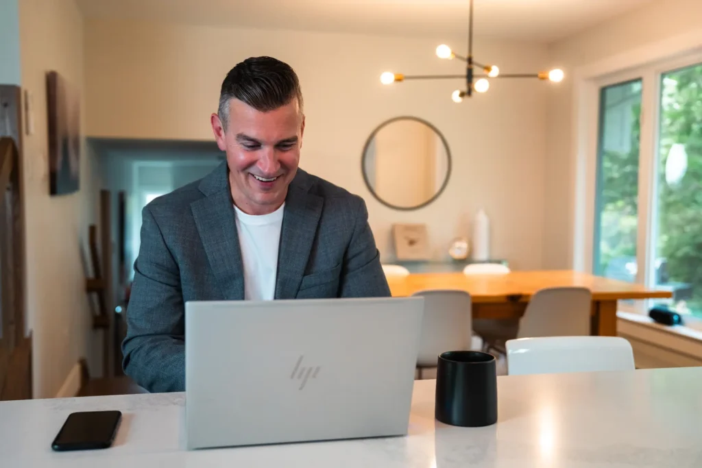 Rob Bennett sitting in front of a laptop with a blurred background, offering assistance for property inquiries.