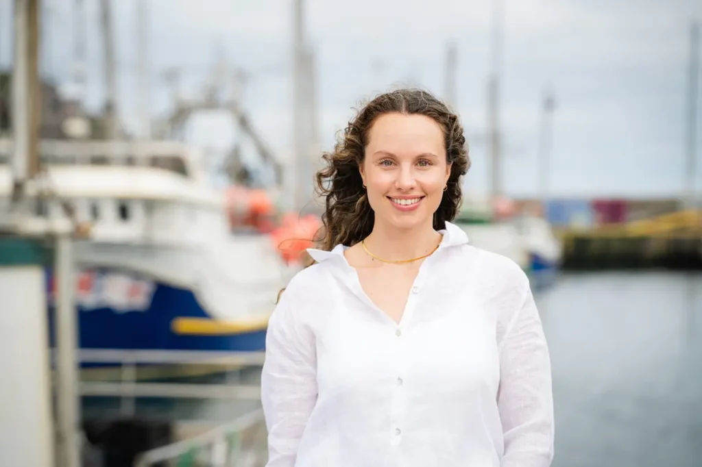 Kelia Cadigan, founder of The Harbour, smiling at the camera at St. John's Harbour, wearing a white shirt.